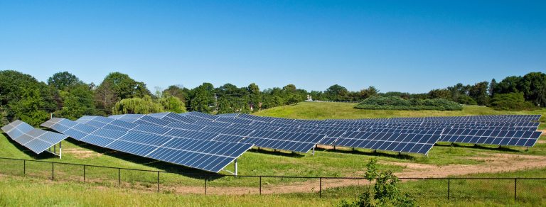 a view of solar panels in a field on a beautiful clear day